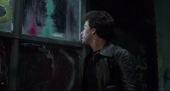 Movie still from “Saturday Night Fever” (1977), directed by John Badham – A man wearing a leather jacket looking out of a window; Close Up shot, Low angle