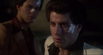 Movie still from “Saturday Night Fever” (1977), directed by John Badham – A man with bandage on his face and another man with bandage on his forehead; Close Up shot, Low angle