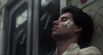 Movie still from “Saturday Night Fever” (1977), directed by John Badham – A man with a bandage on his face; Close Up shot, Low angle
