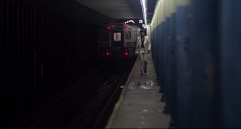 Movie still from “Saturday Night Fever” (1977), directed by John Badham – A man in a white suit walking down a train platform; Wide shot, High angle