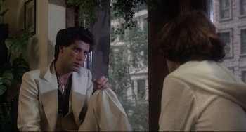 Movie still from “Saturday Night Fever” (1977), directed by John Badham – A man holding a towel in front of a mirror; Medium shot, Over the shoulder angle