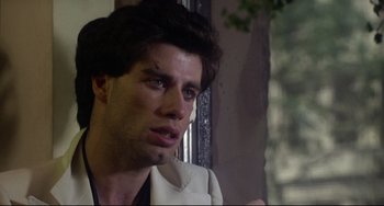 Movie still from “Saturday Night Fever” (1977), directed by John Badham – A person sitting in front of a window; Close Up shot, Over the shoulder angle