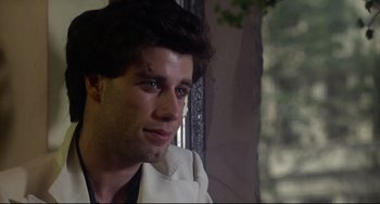 Movie still from “Saturday Night Fever” (1977), directed by John Badham – A person wearing a white shirt; Close Up shot, Over the shoulder angle