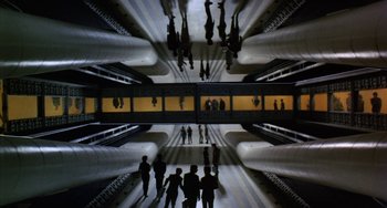 Movie still from “Saturn 3” (1980), directed by John Barry – A group of people standing on a platform; Extreme Wide shot, Overhead angle