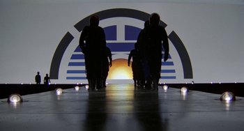 Movie still from “Saturn 3” (1980), directed by John Barry – Two people are walking in front of an archway; Wide shot, Low angle