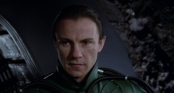 Movie still from “Saturn 3” (1980), directed by John Barry – A person wearing a green jacket; Close Up shot, Low angle