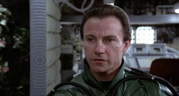 Movie still from “Saturn 3” (1980), directed by John Barry – A person wearing a green jacket; Close Up shot, Low angle