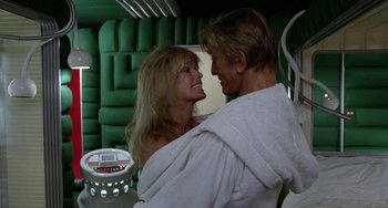 Movie still from “Saturn 3” (1980), directed by John Barry – A man and a woman wrapped in a towel; Medium shot, Over the shoulder angle