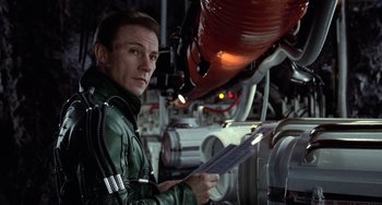 Movie still from “Saturn 3” (1980), directed by John Barry – A man in a green jacket is holding papers; Close Up shot, Over the shoulder angle