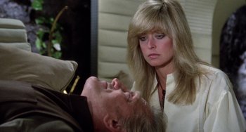 Movie still from “Saturn 3” (1980), directed by John Barry – A woman standing next to a man laying on a bed; Close Up shot, Over the shoulder angle