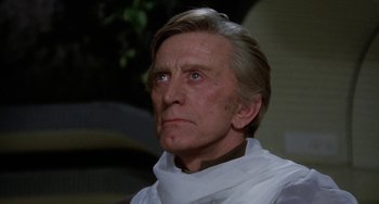 Movie still from “Saturn 3” (1980), directed by John Barry – An older man wearing a white shirt and a white neck tie; Close Up shot, Low angle