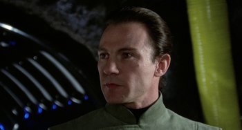 Movie still from “Saturn 3” (1980), directed by John Barry – A person wearing a green shirt; Close Up shot, Low angle