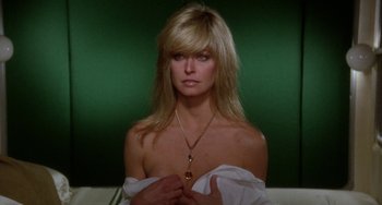 Movie still from “Saturn 3” (1980), directed by John Barry – A beautiful blonde woman wearing a white shirt and a necklace; Close Up shot, Over the shoulder angle