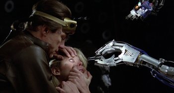 Movie still from “Saturn 3” (1980), directed by John Barry – A man and a woman are in the dark; Close Up shot, Over the shoulder angle