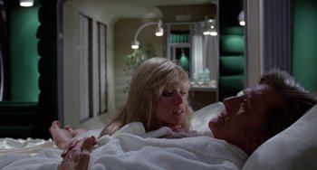 Movie still from “Saturn 3” (1980), directed by John Barry – A man and a woman laying in a bed together; Medium shot, Over the shoulder angle