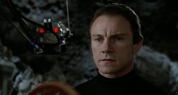 Movie still from “Saturn 3” (1980), directed by John Barry – A person wearing a black shirt; Close Up shot, Low angle