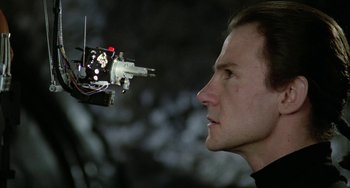 Movie still from “Saturn 3” (1980), directed by John Barry – A person looking at an object; Close Up shot, Low angle