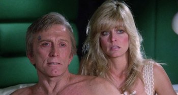 Movie still from “Saturn 3” (1980), directed by John Barry – A man and a woman pose for a picture; Close Up shot, Low angle