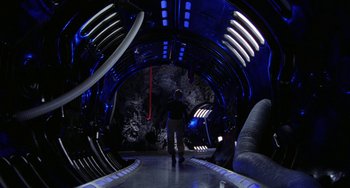 Movie still from “Saturn 3” (1980), directed by John Barry – A man standing inside of an underground tunnel; Wide shot, High angle