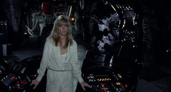Movie still from “Saturn 3” (1980), directed by John Barry – A woman standing in front of a control panel; Medium shot, High angle