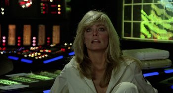 Movie still from “Saturn 3” (1980), directed by John Barry – A woman in white shirt sitting in front of a control panel; Close Up shot, Low angle