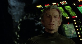 Movie still from “Saturn 3” (1980), directed by John Barry – An older man is looking at the camera; Close Up shot, Over the shoulder angle
