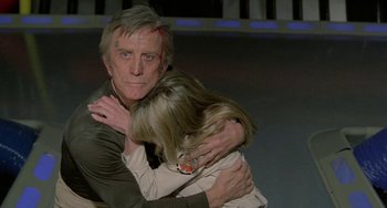 Movie still from “Saturn 3” (1980), directed by John Barry – A man and a woman hugging each other; Close Up shot, Over the shoulder angle