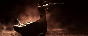 Movie still from “Godless” (2017), directed by Scott Frank – A man is holding a gun in the dark; Wide shot, Low angle