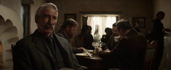 Movie still from “Godless” (2017), directed by Scott Frank – A group of people sitting at a table eating food; Medium shot, Over the shoulder angle