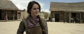 Movie still from “Godless” (2017), directed by Scott Frank – A woman with a long braid wearing an apron; Close Up shot, Over the shoulder angle