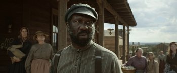Movie still from “Godless” (2017), directed by Scott Frank – A man with a beard wearing a hat and suspenders; Close Up shot, Low angle