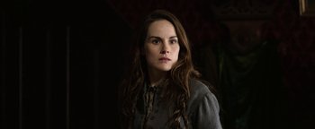 Movie still from “Godless” (2017), directed by Scott Frank – A woman with long brown hair wearing a gray shirt; Close Up shot, Over the shoulder angle