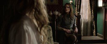 Movie still from “Godless” (2017), directed by Scott Frank – A woman sitting in front of a mirror in a room; Medium shot, Over the shoulder angle