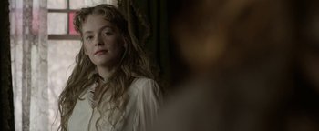 Movie still from “Godless” (2017), directed by Scott Frank – A young girl in a white dress is looking at the camera; Close Up shot, Over the shoulder angle