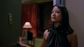 Movie still from “Saving Face” (2004), directed by Alice Wu – A woman standing in a room with a lamp in the background; Close Up shot, Over the shoulder angle