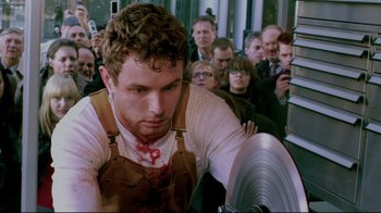 Movie still from “Saw 3D” (2010), directed by Kevin Greutert – A man with a knife in his hand and blood on his face; Medium shot, High angle