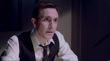 Movie still from “Saw 3D” (2010), directed by Kevin Greutert – A person wearing a suit and tie; Close Up shot, High angle