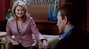 Movie still from “Saw 3D” (2010), directed by Kevin Greutert – A man and a woman sitting on a couch in front of a wall; Medium shot, Over the shoulder angle