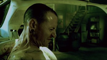 Movie still from “Saw 3D” (2010), directed by Kevin Greutert – A man with a tattoo on his face; Close Up shot, Low angle