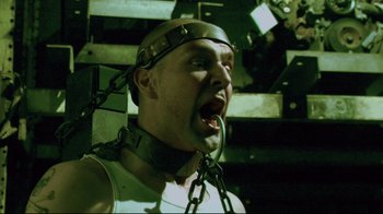 Movie still from “Saw 3D” (2010), directed by Kevin Greutert – A man with chains around his neck and head; Close Up shot, Low angle