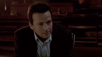 Movie still from “Saw 3D” (2010), directed by Kevin Greutert – A person wearing a suit and tie; Close Up shot, Over the shoulder angle