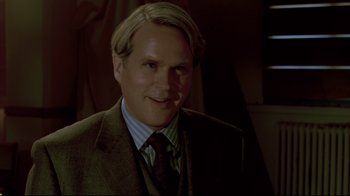 Movie still from “Saw 3D” (2010), directed by Kevin Greutert – A person wearing a suit and tie; Close Up shot, Over the shoulder angle