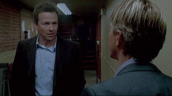 Movie still from “Saw 3D” (2010), directed by Kevin Greutert – A man in a suit talking to another man in a suit; Medium shot, Over the shoulder angle