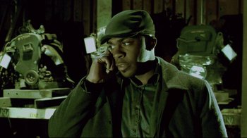Movie still from “Saw 3D” (2010), directed by Kevin Greutert – A man wearing a hat talking on a cell phone; Close Up shot, Low angle