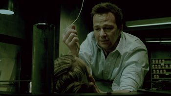 Movie still from “Saw 3D” (2010), directed by Kevin Greutert – A man holding a woman's ear while she looks into the mirror; Close Up shot, Over the shoulder angle