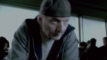 Movie still from “Saw 3D” (2010), directed by Kevin Greutert – An older man with a hat on looking into the distance; Close Up shot, Low angle