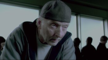 Movie still from “Saw 3D” (2010), directed by Kevin Greutert – An older man wearing a hat and looking at the camera; Close Up shot, Low angle
