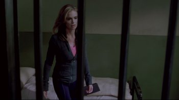 Movie still from “Saw 3D” (2010), directed by Kevin Greutert – A woman standing in front of a bed in a room; Medium shot, Over the shoulder angle