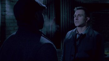 Movie still from “Saw 3D” (2010), directed by Kevin Greutert – A man in a hat and a jacket standing next to another man in a suit; Close Up shot, Over the shoulder angle