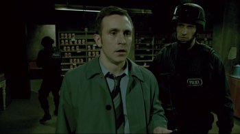 Movie still from “Saw 3D” (2010), directed by Kevin Greutert – A man wearing a green jacket and a black tie; Medium shot, Over the shoulder angle